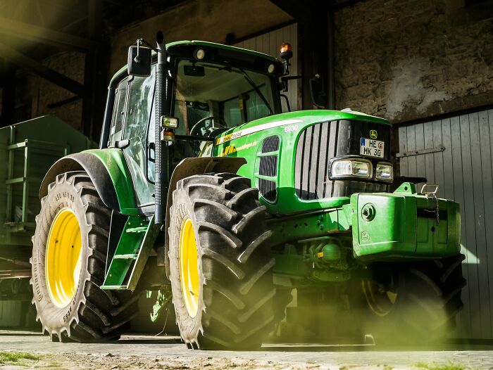 A large green tractor parked in front of a barn, symbolizing complex cases and arguments heard in court.