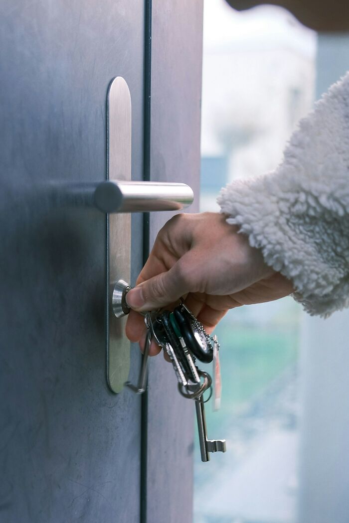 A woman is seen locking the door to protect herself. Women living alone can use safety tips to protect themselves.