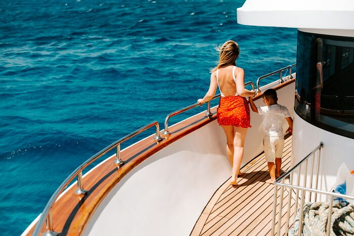 A woman and child walking on a yacht deck, with the ocean in the background, a reminder of stupid things people said.