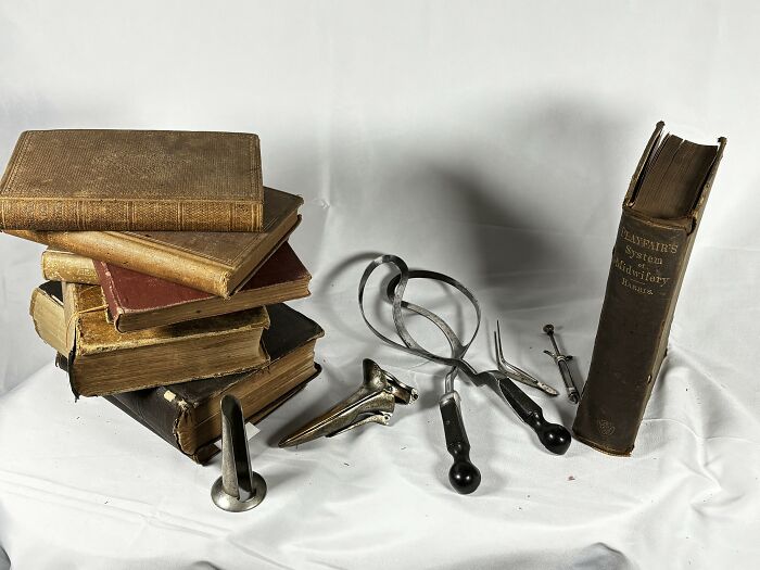 Old textbooks and forceps showing tools from medical history