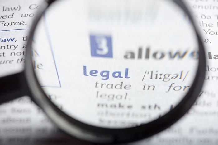 Magnifying glass over the word legal in a dictionary, representing the legal action taken against the landlord for the deposit. Magnifying glass over the word legal in a dictionary, representing the legal action taken against the landlord for the deposit.