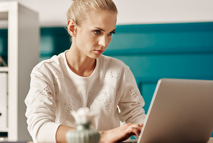 Woman looking intently at a laptop, researching how to sue landlord for deposit. Woman looking intently at a laptop, researching how to sue landlord for deposit.