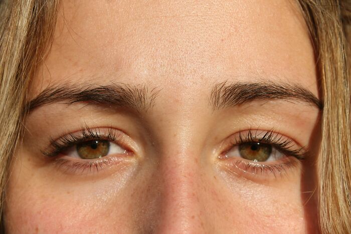 Extreme close-up of a woman's brown eyes, illustrating her concerns about blurry vision.