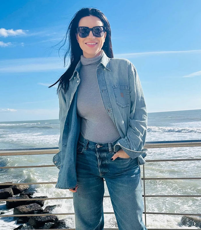Laura Pausini by the sea in sunglasses, showcasing a moment of Instagram versus reality.