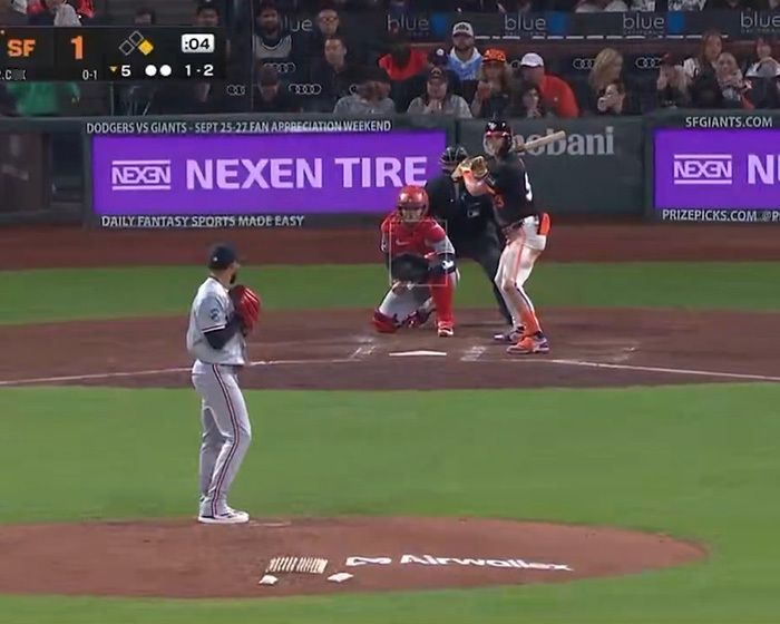 A baseball game in progress with a pitcher on the mound, a batter ready, and Nexen Tire signs in the background. A baseball game in progress with a pitcher on the mound, a batter ready, and Nexen Tire signs in the background.
