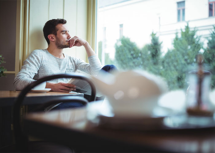 Pensive man contemplates wife's ultimatum and his caregiving role for sick mom