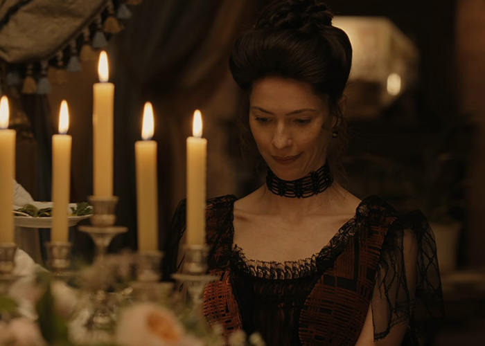Woman in dark lace dress sitting by candles in Lizzie Borden series Woman in dark lace dress sitting by candles in Lizzie Borden series