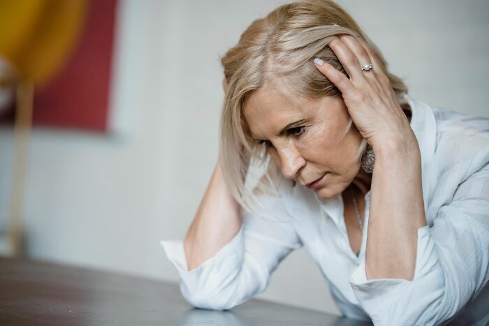 A woman looking distressed with hands on her head, depicting emotional struggles in a marriage over 20 years.