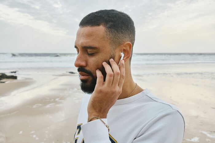 A man with earbuds on a beach, contemplating a marriage that lasted 20 years before something switched.