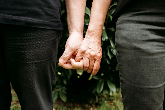 A close-up of an elderly couple holding hands, symbolizing a long-lasting marriage and enduring love.