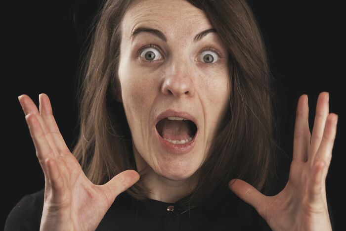 A woman with wide eyes and an open mouth, expressing shock or distress after many years in a marriage.