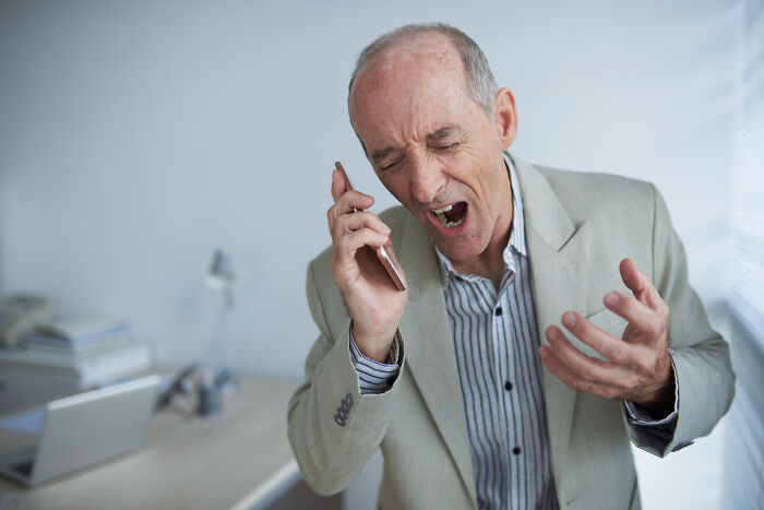 An angry man shouting into a phone, illustrating conflict that can arise in a marriage after 20 years.