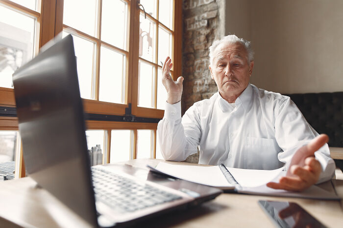 An older man looking frustrated at his laptop, symbolizing challenges in a marriage over 20 years.