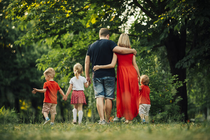 A family with two parents and three young children walking away, symbolizing the desire to avoid divorce.