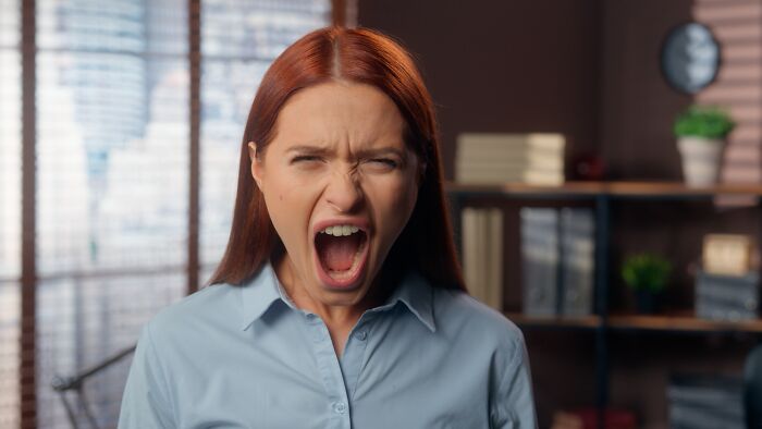 An angry woman screaming, symbolizing a breakdown in a divorced marriage