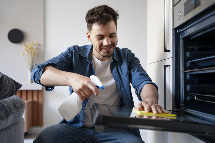 Man cleaning an oven, reflecting on what he wished he had known before divorce.