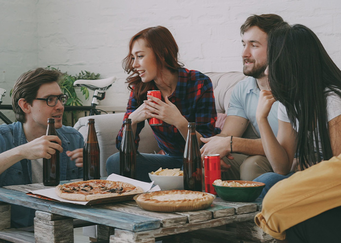 Friends hanging out at home showing how men should treat women in social settings.