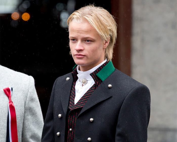 Son of Norway's Crown attends royal funeral, dressed in traditional attire.