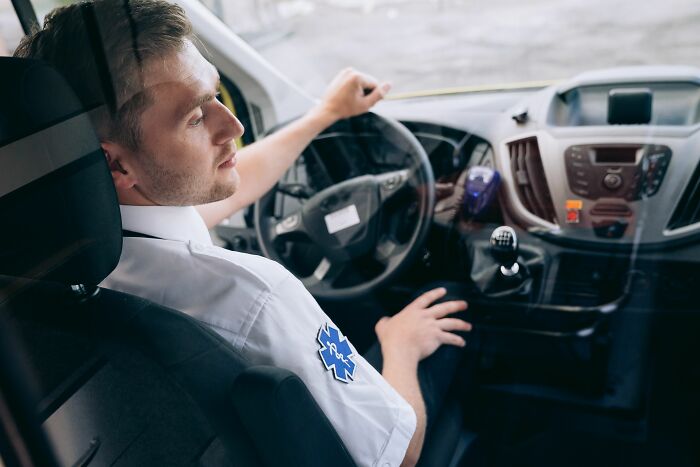An EMS medical worker driving an ambulance, ready to help with patient stories.