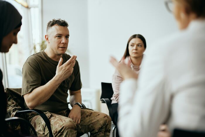 A group therapy session with a military patient sharing stories with a therapist