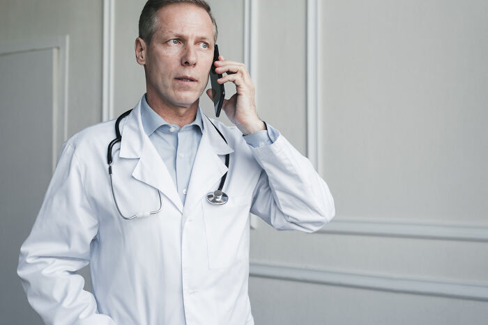 A medical worker on his phone, sharing patient stories during a busy day.