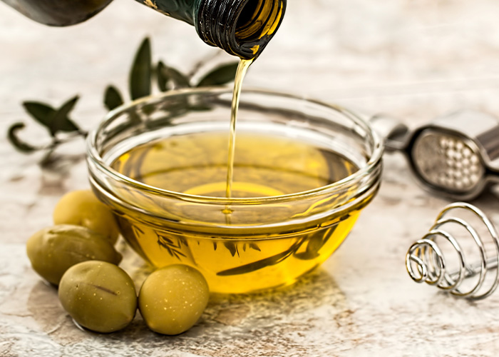Pouring olive oil into a bowl, central to a Mediterranean Diet study.