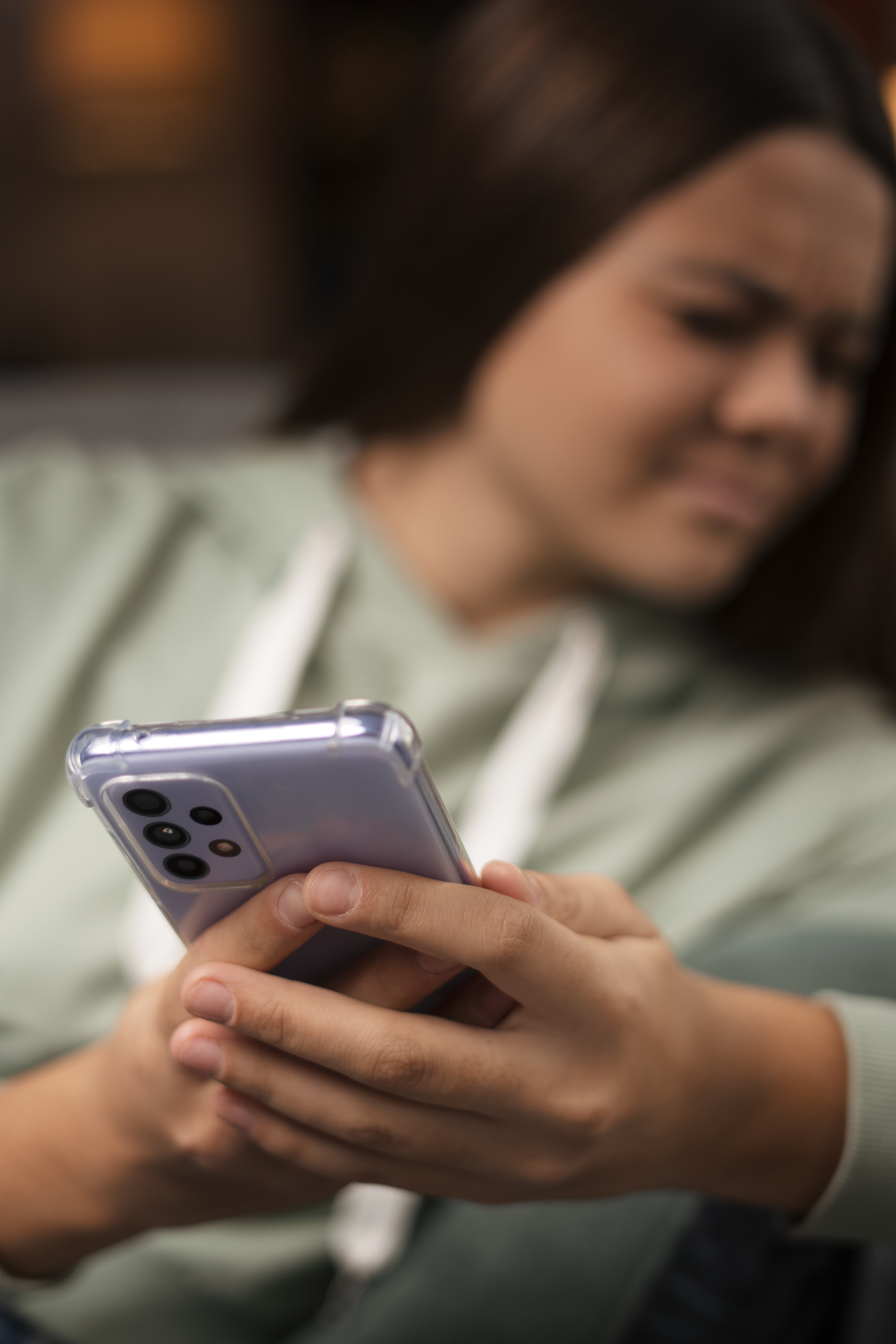 Woman looking frustrated at phone with babysitting text message
