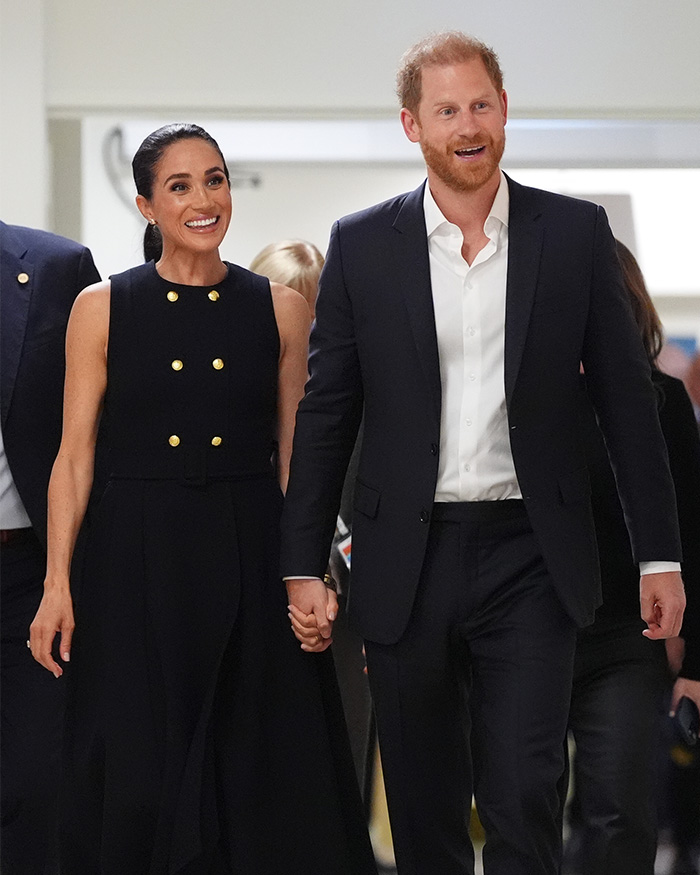 Meghan Markle and Prince Harry hand-in-hand, smiling, amidst backlash over Meghan Markle's complaint about UK life. Meghan Markle and Prince Harry hand-in-hand, smiling, amidst backlash over Meghan Markle's complaint about UK life.