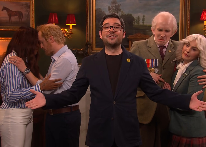 Cast members portraying Meghan Markle and Prince Harry along with a host on a show post UK move. Cast members portraying Meghan Markle and Prince Harry along with a host on a show post UK move.