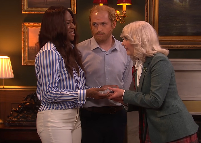 Actors portraying Meghan Markle, Catherine, and William, trying to be royal in a sketch after moving to the UK. Actors portraying Meghan Markle, Catherine, and William, trying to be royal in a sketch after moving to the UK.