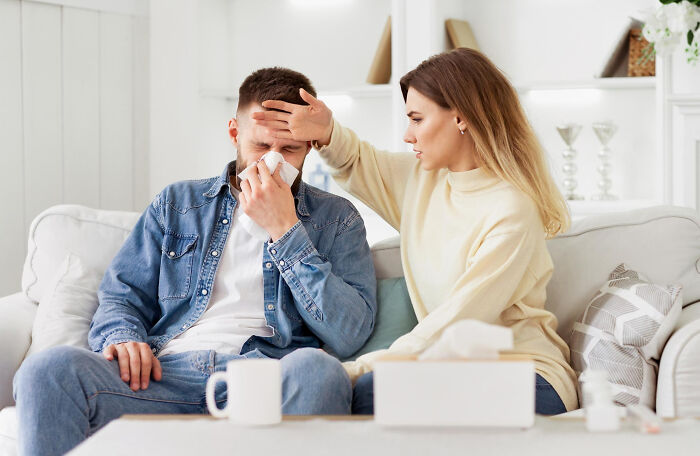 Woman checking forehead of sick man showing care despite toxic relationship traits