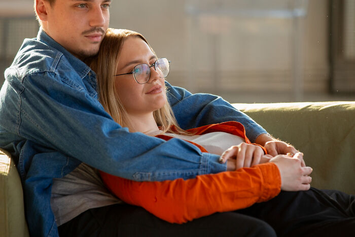 Couple embracing peacefully on couch after overcoming toxic traits