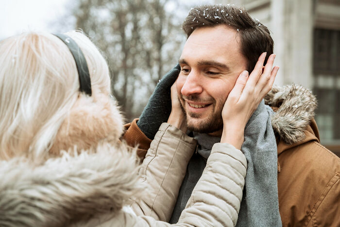 Woman lovingly comforting man with toxic traits during winter outdoors