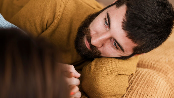 Man lying down looking sad depicting toxic traits in relationships