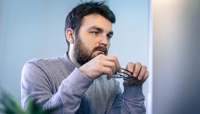 Man stressed and holding glasses showing toxic traits in love life