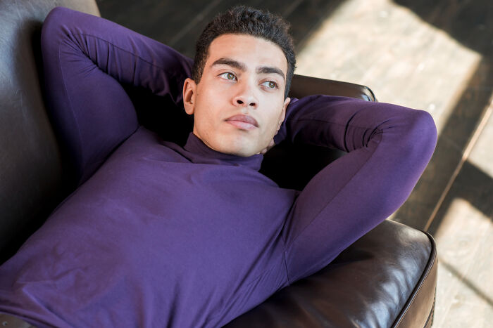 Man in purple shirt lying back looking thoughtful about toxic relationship traits