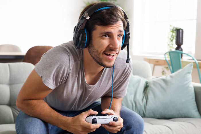 Man wearing gaming headset intensely playing video games, reflecting ex-boyfriend distractions