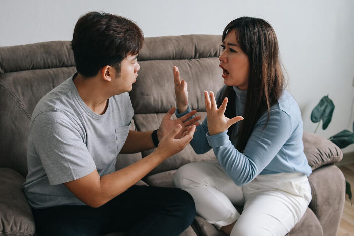 Couple arguing on couch illustrating toxic traits in love lives