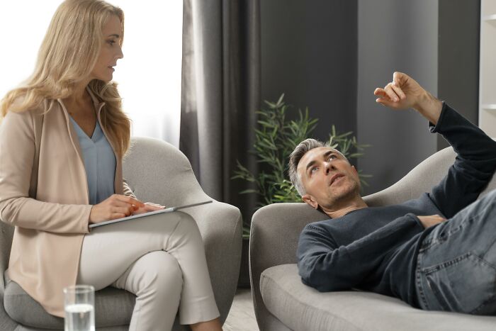 A man lies on a therapist couch, discussing his personal marriage regrets