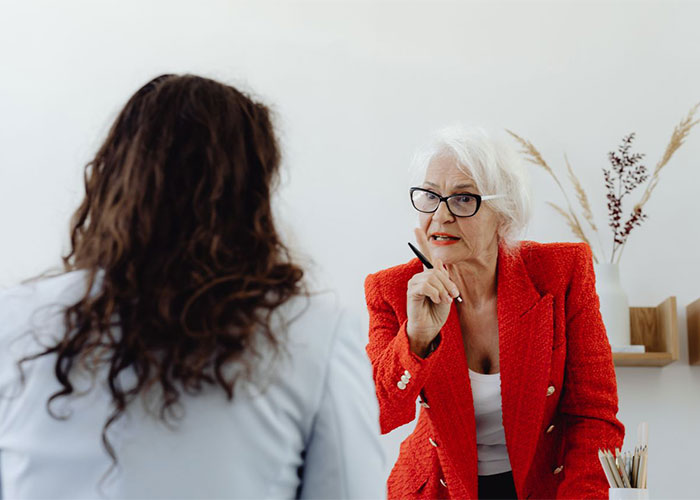 A woman in a red jacket expressing anger towards another woman, revealing why she is angry with her.