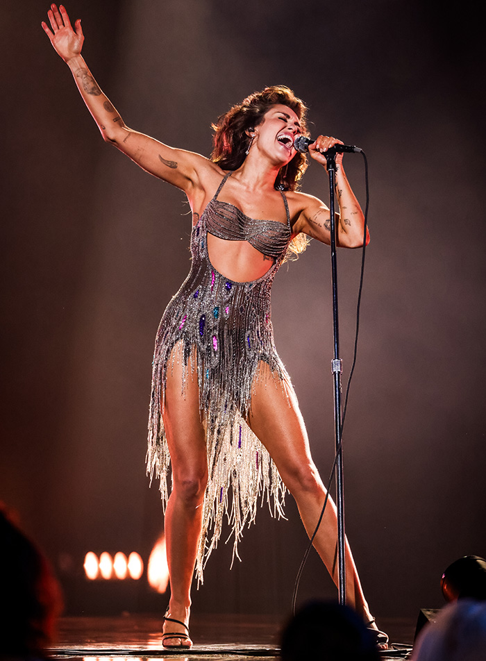Miley Cyrus performs on stage, highlighting significant incidents from her life.