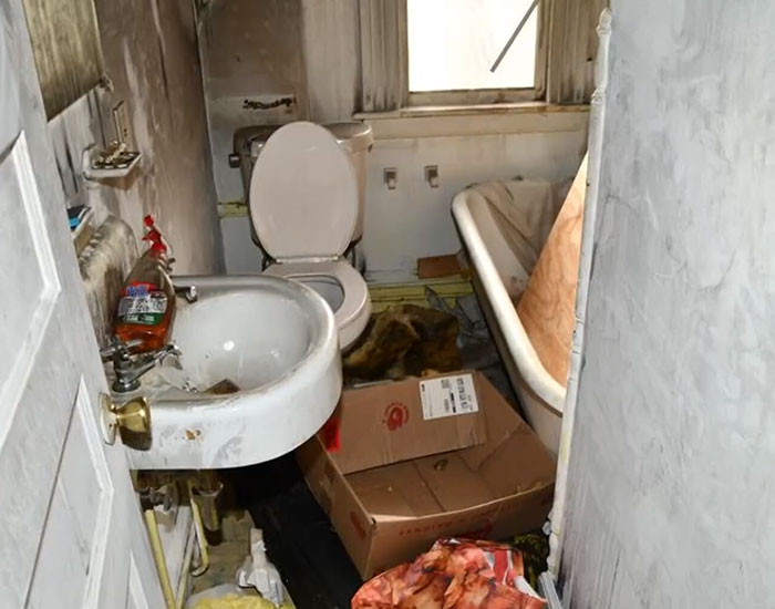A dirty bathroom with a toilet, sink, and bathtub in the house where a stepson was held captive. A dirty bathroom with a toilet, sink, and bathtub in the house where a stepson was held captive.