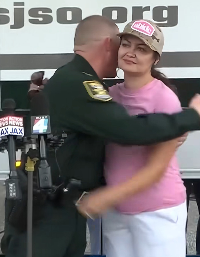 A police officer hugs the mom during the press conference where her missing son was found.