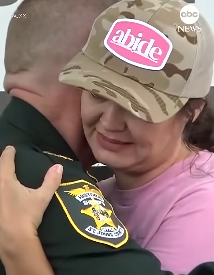 A mom hugs an officer during a press conference about her missing son being found.