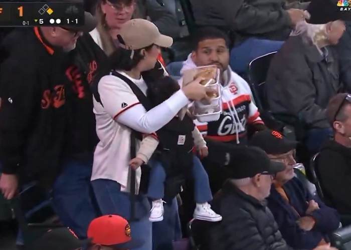 Mom of the year feeding child at Giants baseball game with crowd around