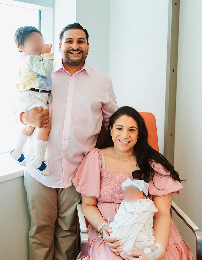 Family portrait with parents and two young children in casual attire