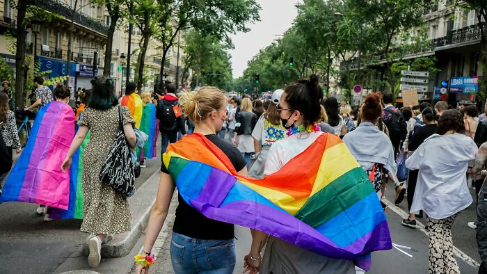 People at a pride parade, celebrating freedom and questioning legal excuses.