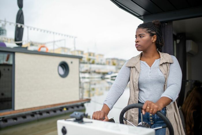 A woman at the helm of a boat, contemplating legal excuses.