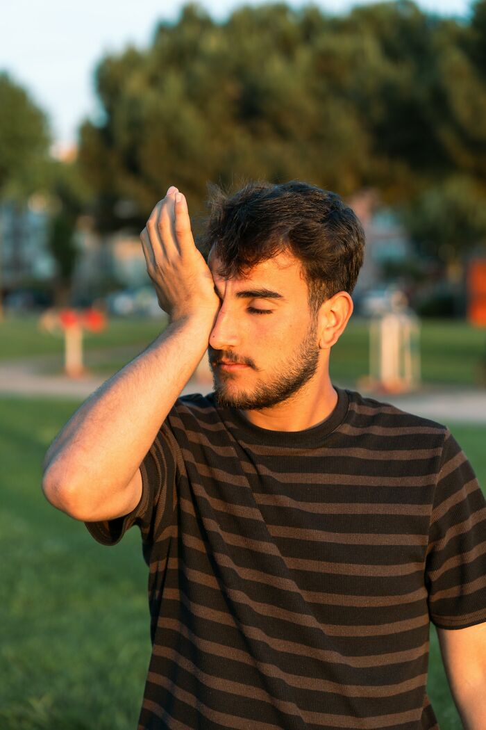 A man with a beard covers his face with his hand, looking stressed about legal excuses.