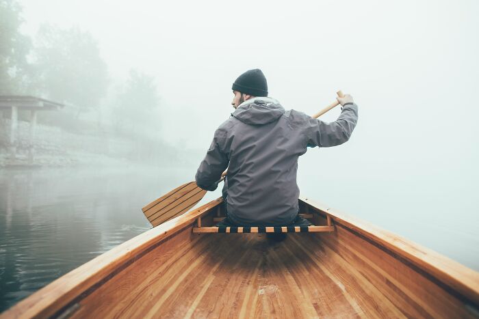Man canoeing in fog, reflecting on a midlife crisis.